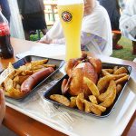 東京オクトーバーフェストの写真。ビールジョッキとポテト、鶏の丸焼き