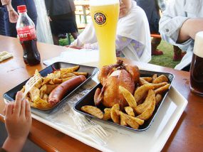 東京オクトーバーフェストの写真。ビールジョッキとポテト、鶏の丸焼き